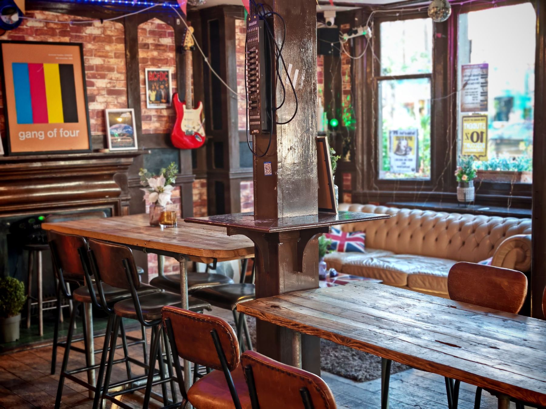 A characterful independent pub interior with exposed brick and reclaimed wood tables.